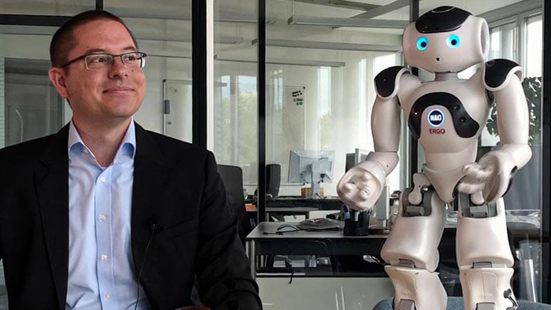 abian Stolz with robot figure Naomi, who embodies the topic of robotics at ERGO